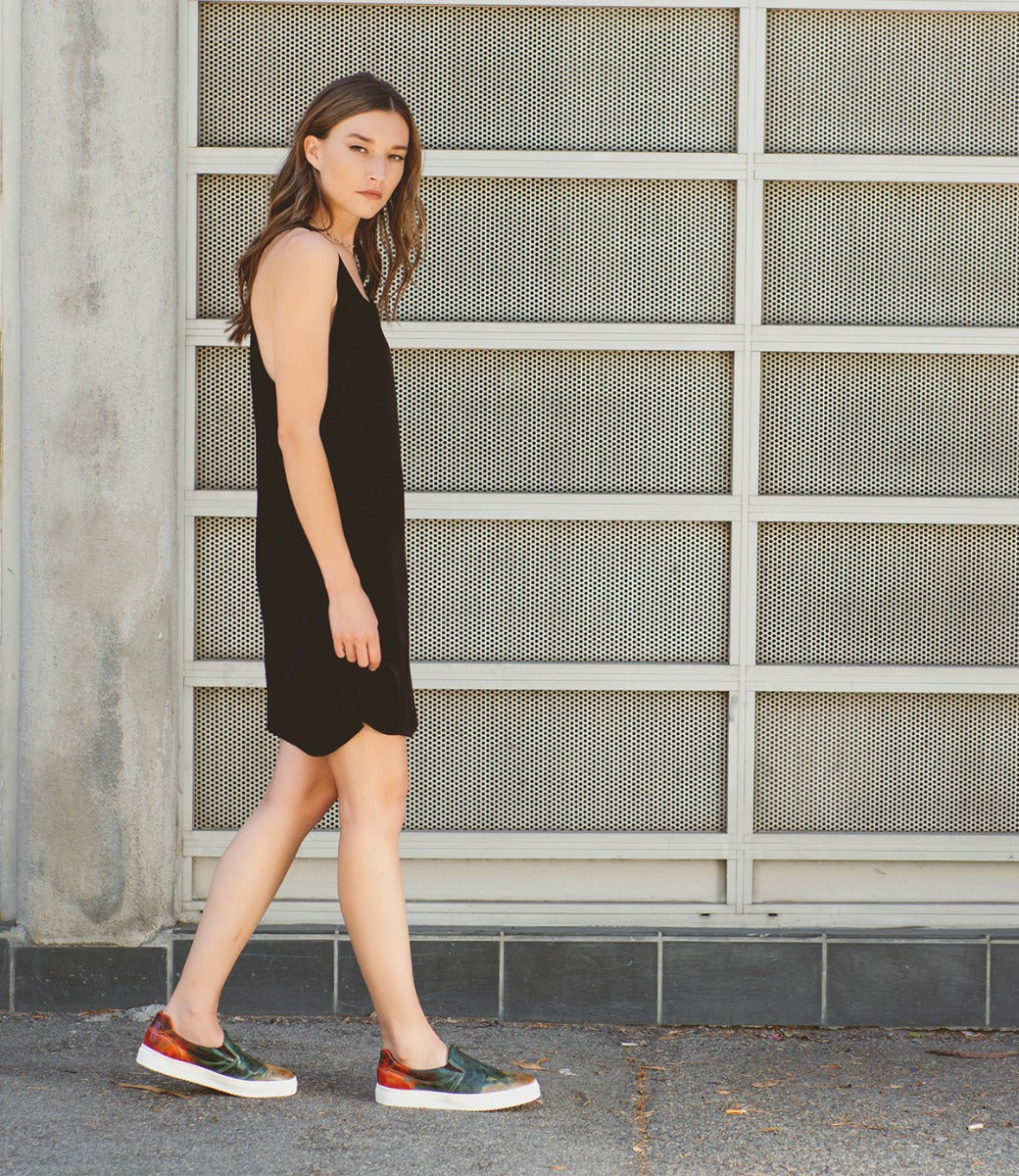 A woman wearing a black dress and Bed Stu Hermione sneakers.
