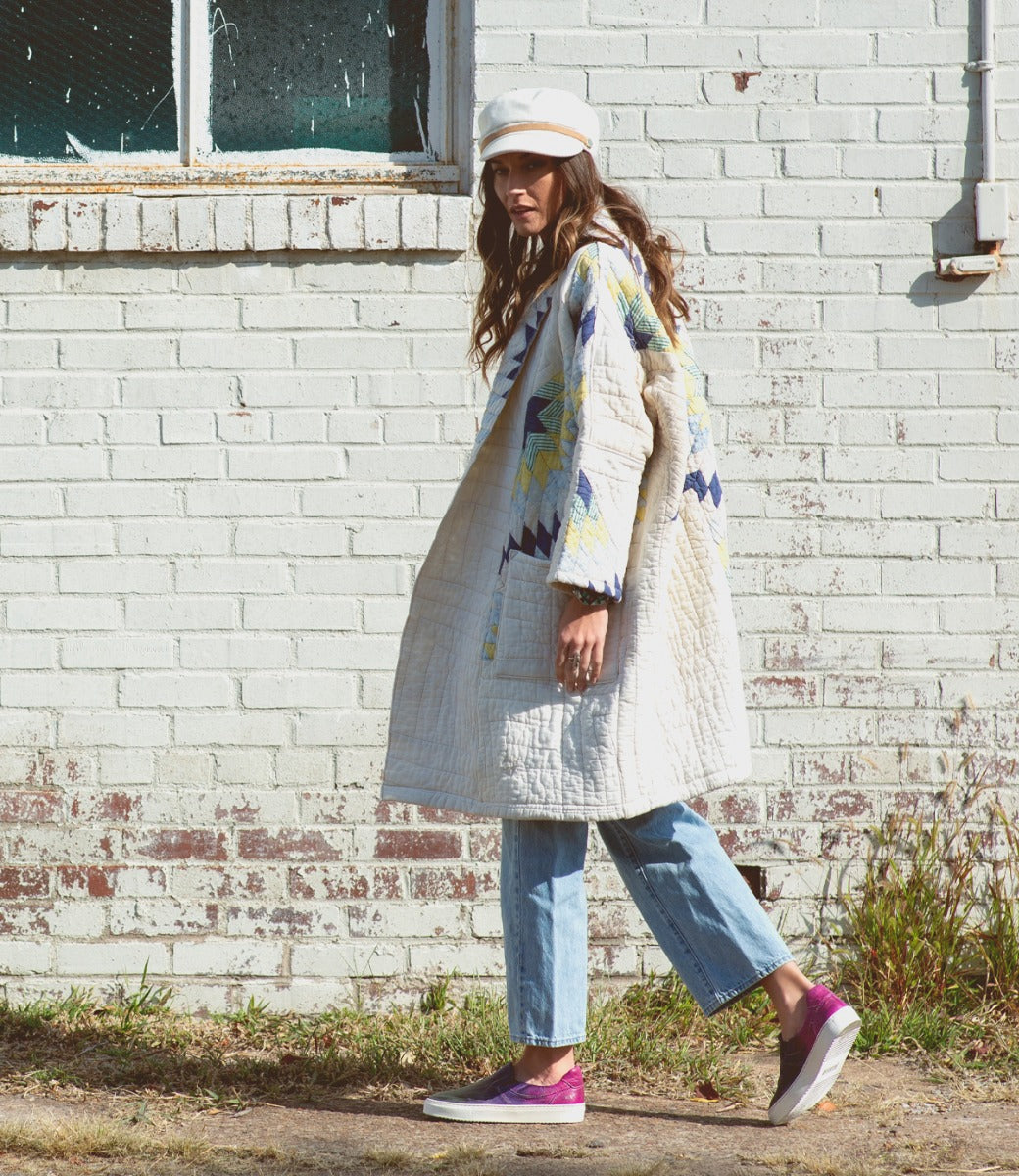 A woman wearing a white Bed Stu coat and Hermione sneakers.