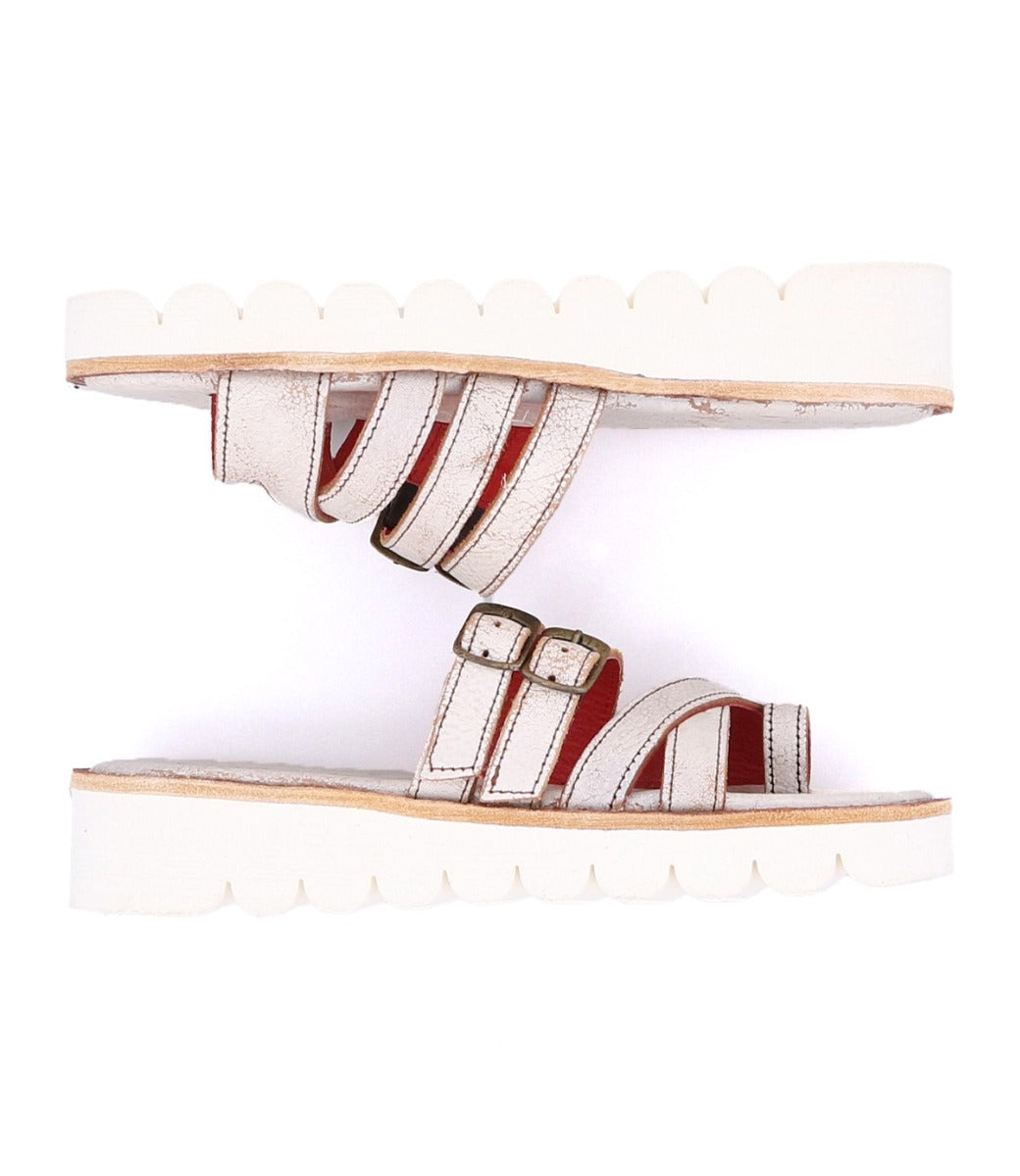 A pair of white sandals with straps and buckles by Bed Stu.