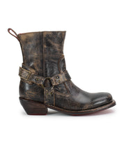 A single Bed|Stü Homage distressed brown leather boot featuring a low heel, square toe, harness strap, and metal buckles, shown from the side against a white background.