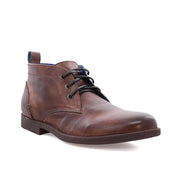 A brown vegetable-tanned leather Illiad chukka boot with blue laces, isolated on a white background by Bed Stu.
