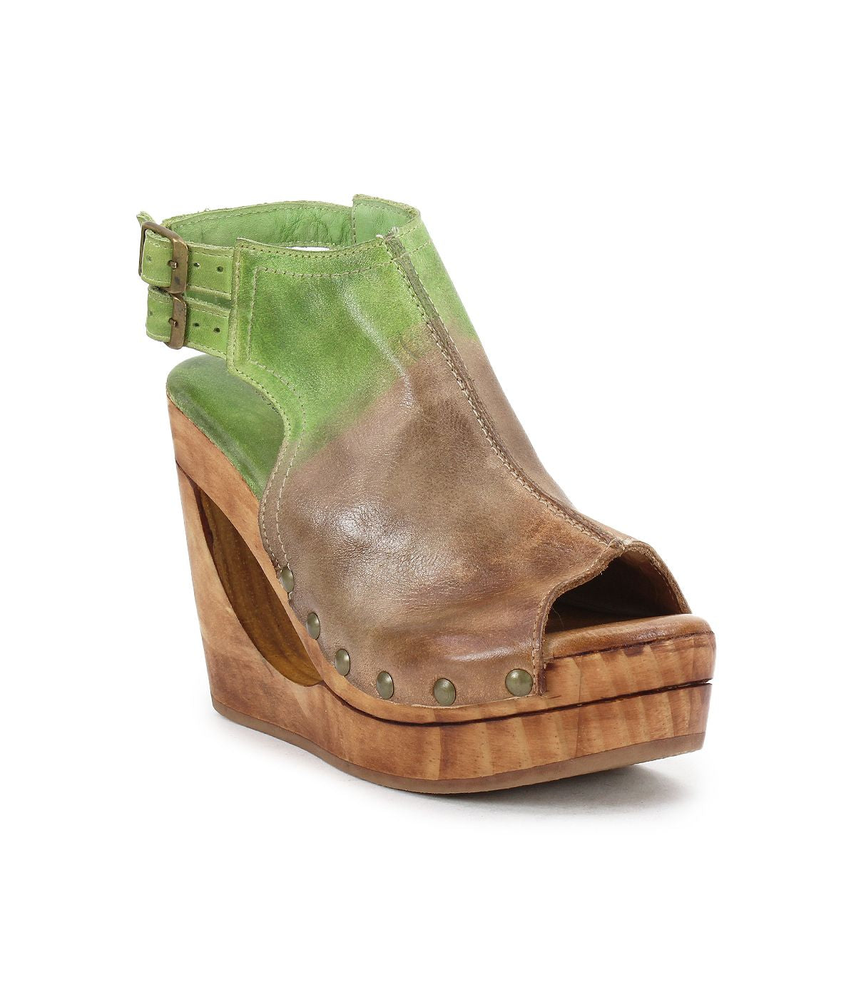 The Imelda by Bed Stu is a green and brown open-toe wedge sandal with a distinctive cutout, wooden platform, and buckle strap.