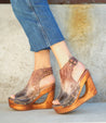 A woman wearing a pair of Bed Stu Imelda wooden wedges.