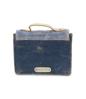 A worn, dark blue leather bag with a tan handle and trim from Bed Stu's Improv collection. The flap features a metal plate engraved with the word "beautiful." Equipped with a versatile crossbody strap, it seamlessly blends fashion and functionality.
