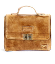 The Improv by Bed Stu is a brown leather satchel featuring a top handle, front buckle clasp, embossed brand name on the flap, and a handy crossbody strap for added fashion and functionality.