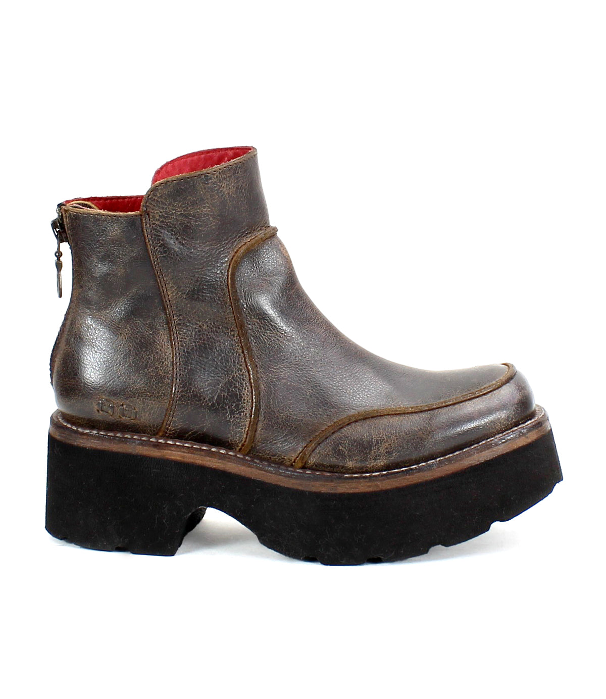 The Infamy by Bed Stu is a brown leather ankle boot with a back zipper, highlighted by a chunky black platform sole. This striking platform boot design is enhanced with high-quality leather finishes, providing both style and durability for any fashion-forward wardrobe.