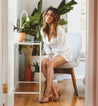 A woman sitting on a chair in front of a Bed Stu Ireni.