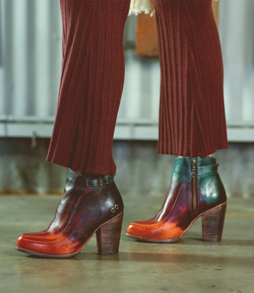 A woman wearing a pair of colorful Isla ankle boots from Bed Stu.