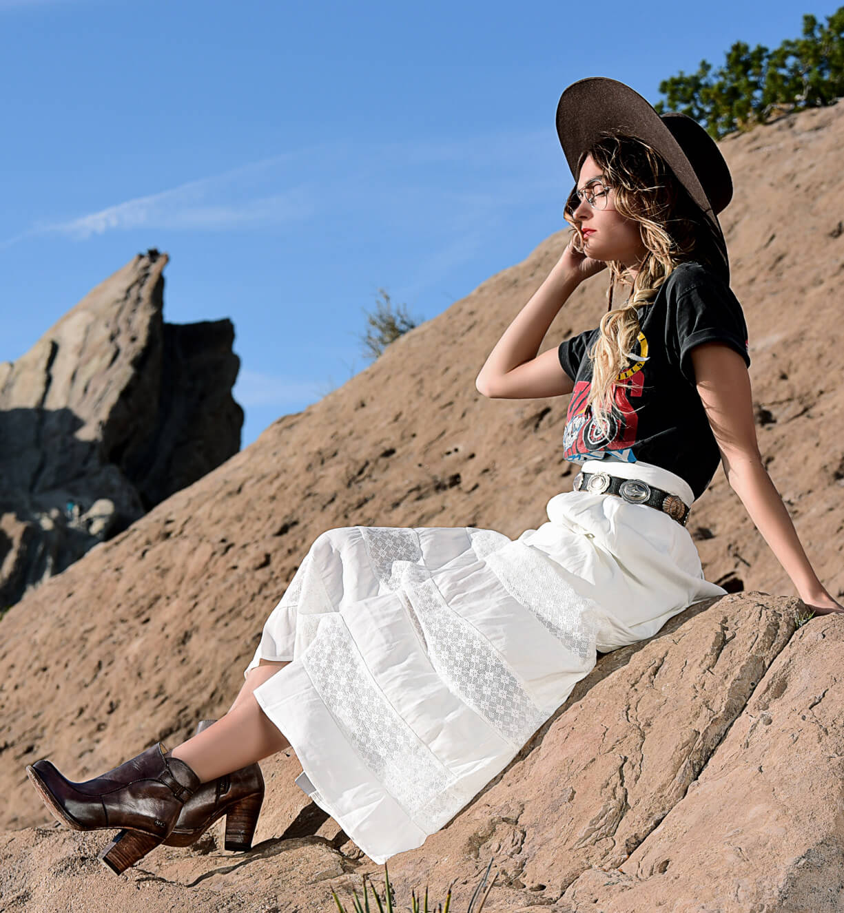 A woman sitting on a rock with Isla boots by Bed Stu.
