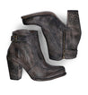 A pair of worn women's leather heeled booties with side zippers and a vintage buckle accent, the Isla boots by Bed Stu.