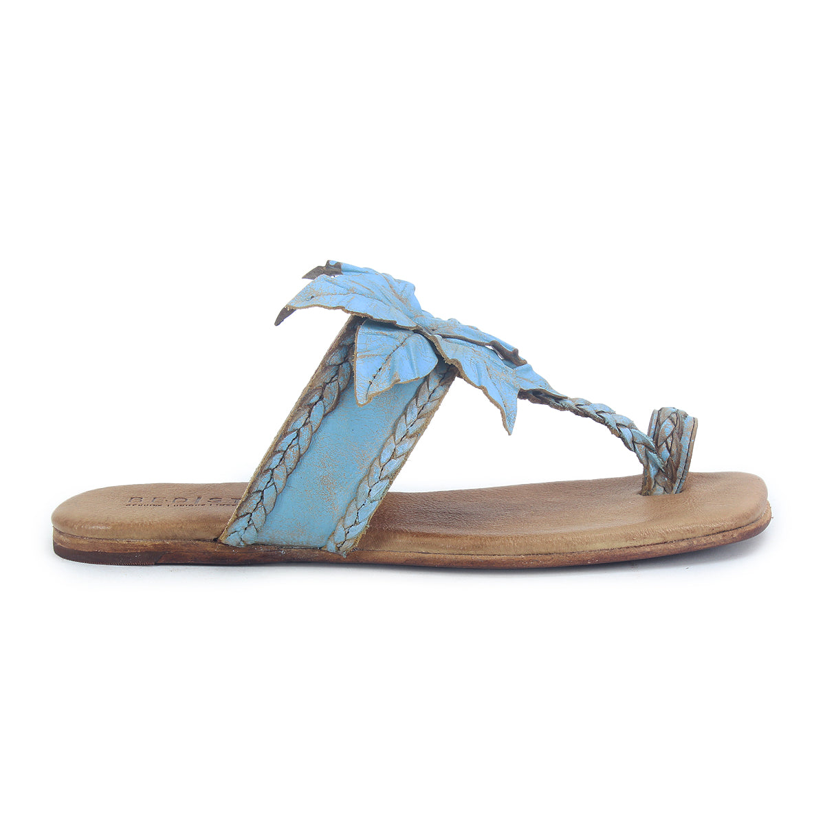 The Bed Stu Isobel is a flat sandal with a tan sole, light blue braided leather straps, a leather flower-shaped leaf accent on top, and a small toe loop.