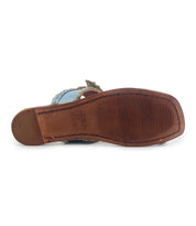 The image shows the bottom view of the Bed Stu Isobel sandal, featuring a brown sole, rectangular heel, visible textured grip lines, and braided leather accents along the edge.