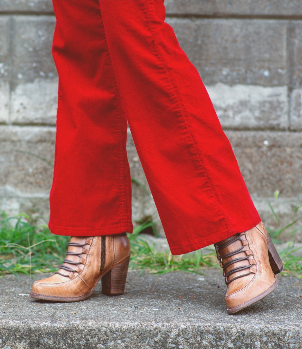 A woman wearing Izetta red pants and Bed Stu brown boots.