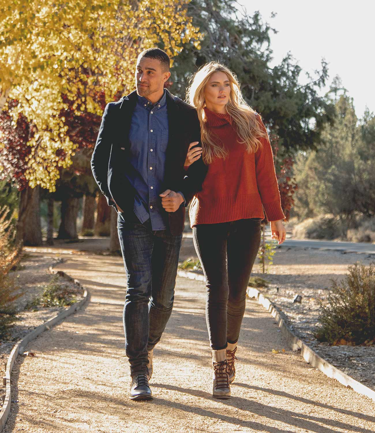 A couple walking down a path in a park wearing Izetta shoes by Bed Stu.