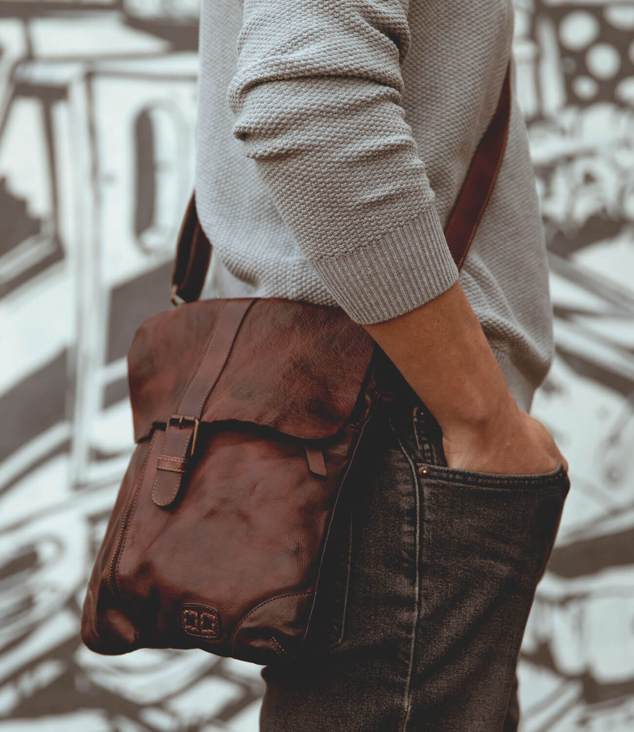 A man is wearing a Jack brown leather bag by Bed Stu.