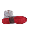 A pair of Jacqueline boots with red soles on a white background by Bed Stu.