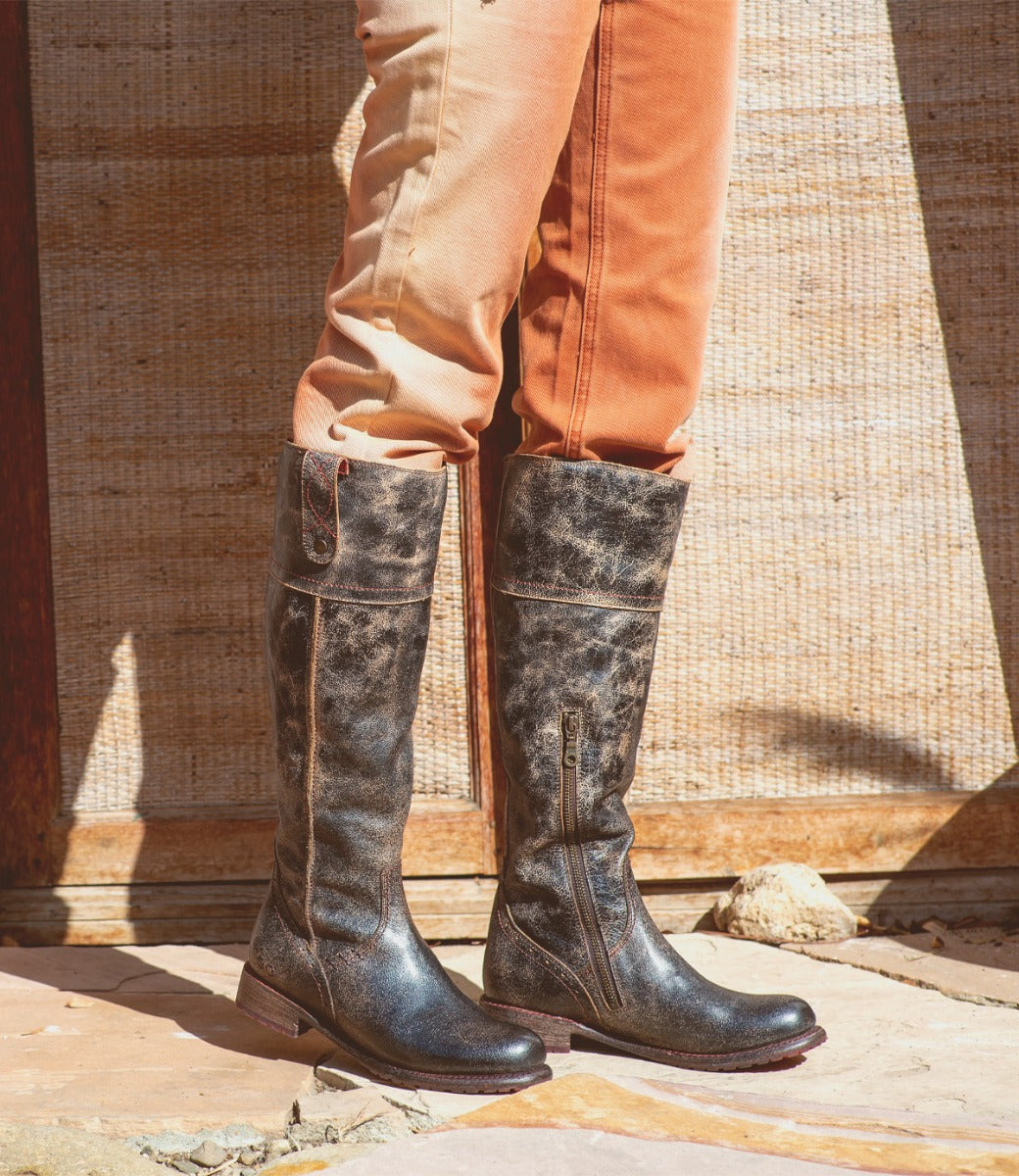 A woman wearing a pair of Bed Stu Jacqueline black leather boots.