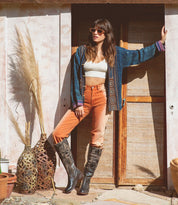 A woman is posing in front of a door wearing the Jacqueline shoes by Bed Stu.