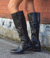 A woman wearing a pair of Bed Stu Jacqueline black leather boots.
