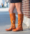 A woman wearing a pair of Bed Stu's Jacqueline tan riding boots.