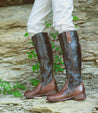 A woman wearing a pair of brown Bed Stu Jacqueline riding boots.