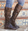 A woman wearing Bed Stu "Jacqueline Wide Calf" brown leather boots standing on steps.