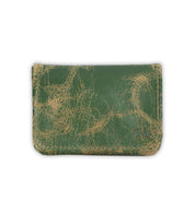 The Bed Stu Jeor is a rustic, compact card holder crafted from worn green leather with visible cracks and faded areas, shown against a white background.