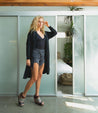 A blonde woman standing in front of a Bed Stu glass door.