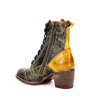 A single distressed Judgement boot by Bed Stu showcasing an 8-eye lace-up design, adorned in black and yellowish-brown tones. It features a side zipper, black laces, a cushioned insole for added comfort, and a wooden heel.