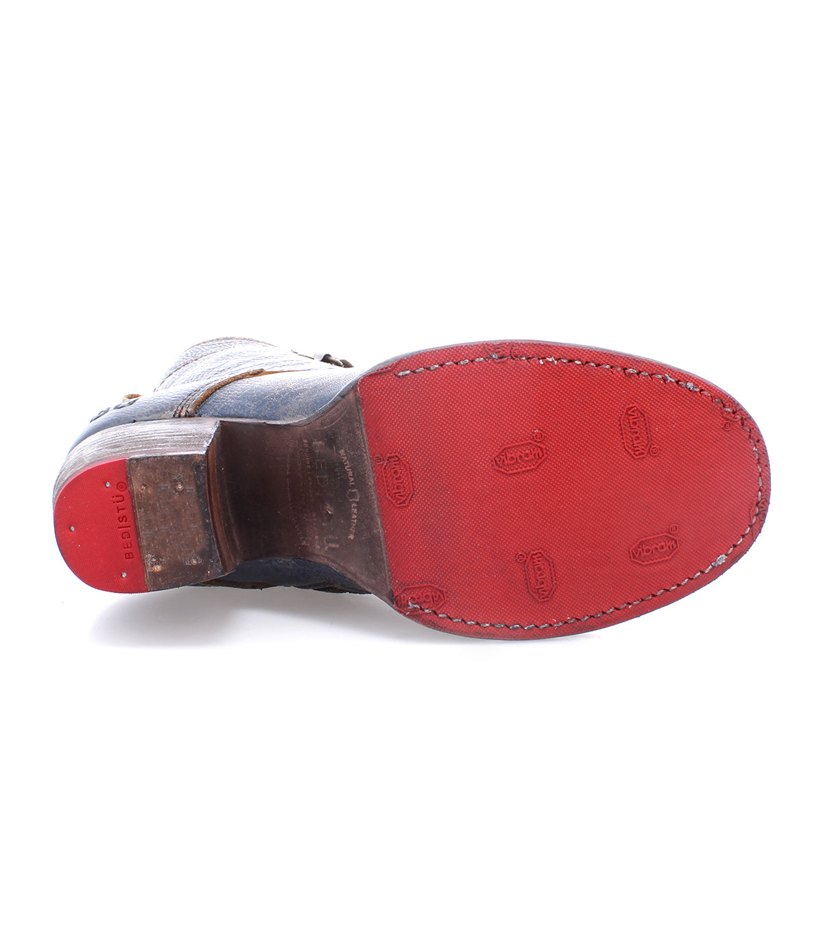 A pair of Bed Stu shoes with red soles on a white background.