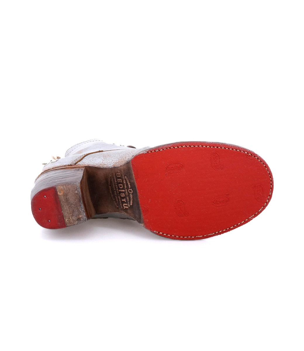 A pair of Bed Stu shoes with red soles on a white background.