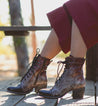 A woman wearing Bed Stu lace up boots on a wooden bench.