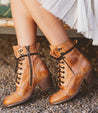 A woman's legs are sitting on a bench wearing Bed Stu Judgement boots.