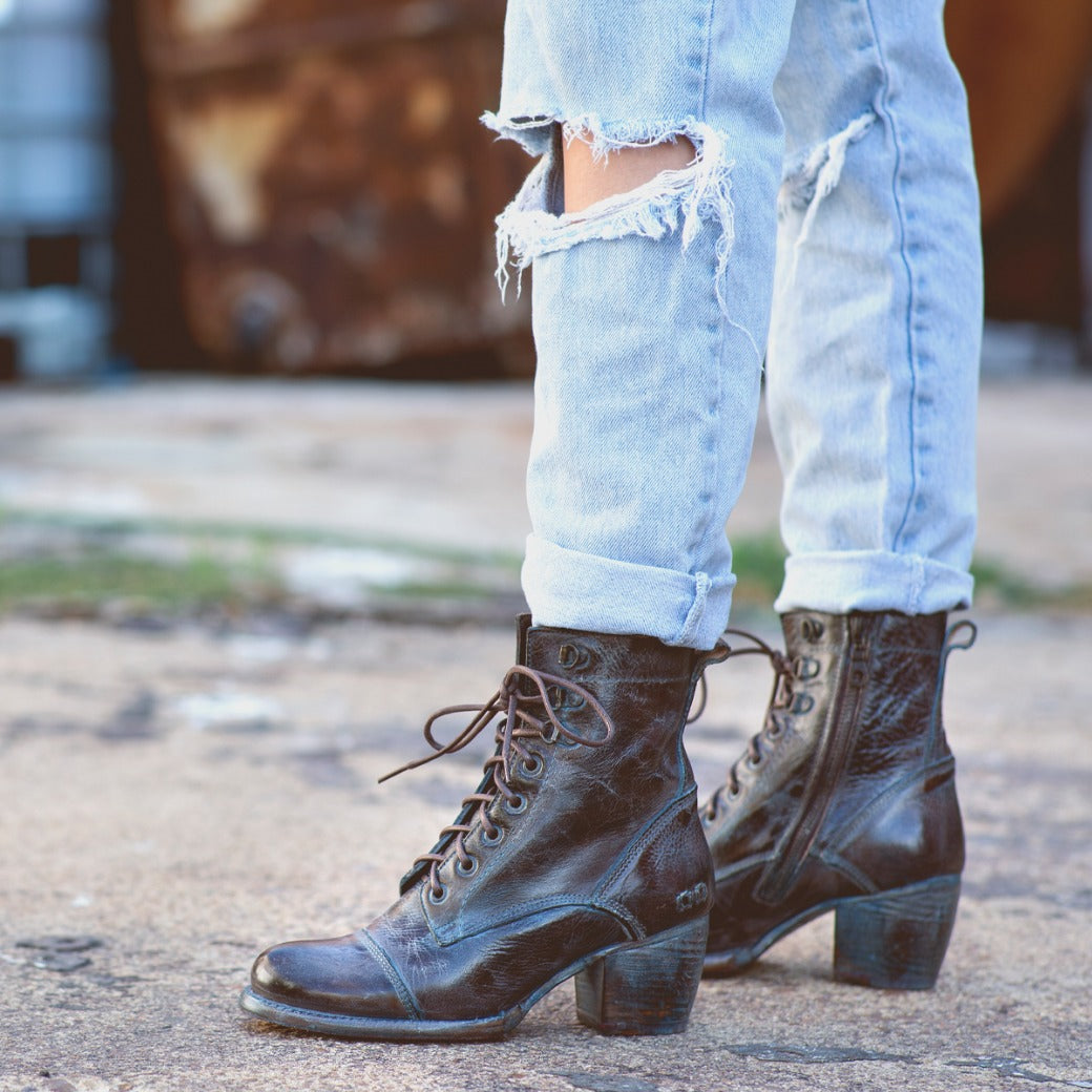 A woman wearing Bed Stu distressed jeans and Bed Stu lace up boots.