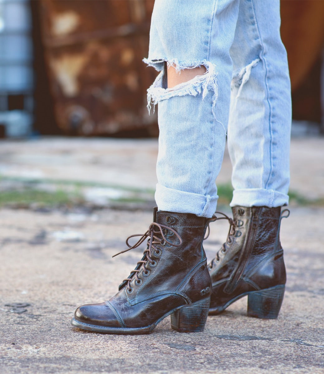 A woman wearing Bed Stu distressed jeans and Bed Stu lace up boots.