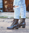 A woman wearing Bed Stu distressed jeans and Bed Stu lace up boots.