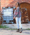 A woman is walking in front of a building wearing Bed Stu's Judgement shoes.