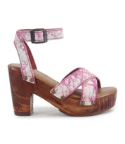 The Kalah sandal by Bed Stu is a pink and white patterned high-heeled shoe with a wooden block heel, ankle strap, and buckle. Crafted with sustainably sourced materials, it combines timeless elegance with comfort thanks to its chic design and platform heel.