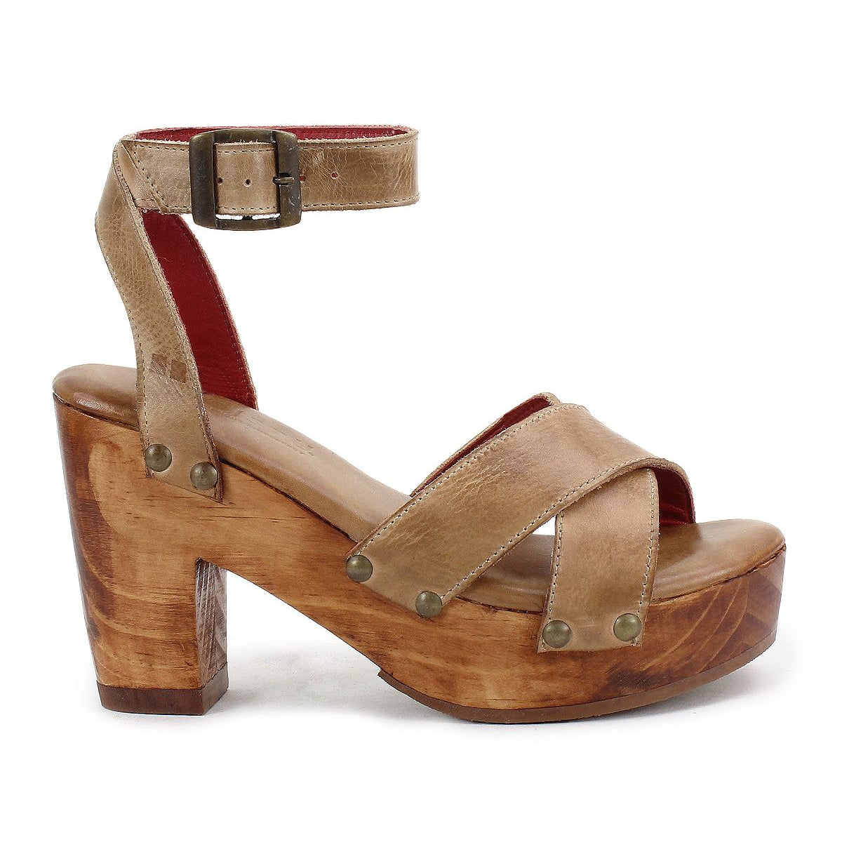 The Kalah sandal by Bed Stu features brown leather, a chunky wooden heel, an ankle strap, and metal rivet details, all crafted from sustainably sourced materials.