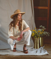 A woman posing in a Kalah hat and Bed Stu sandals.