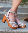 A woman's feet in a pair of Bed Stu Kalah wooden sandals.