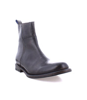 The Kaldi ankle boot by Bed Stu, featuring a classic black leather silhouette with a rounded toe and low heel, is showcased from an angle against a white background.