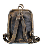 A vintage-style, handcrafted brown leather backpack featuring a zippered front pocket, adjustable straps, and a top handle made from vegetable tanned leather: the Kamet by Bed Stu.