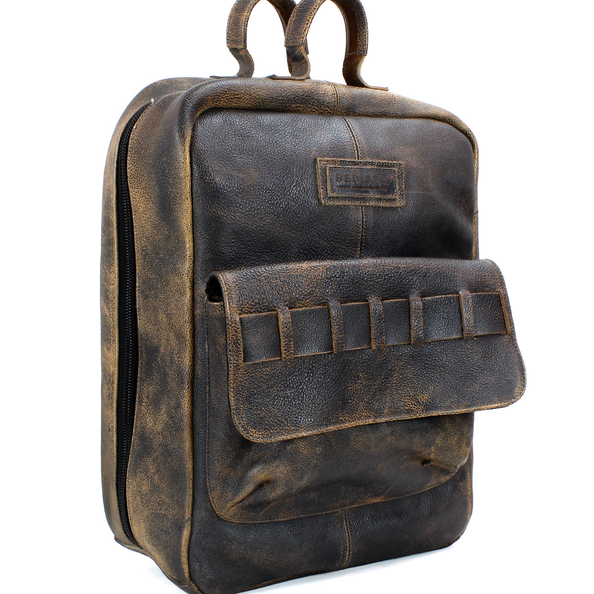 A brown vintage-style, vegetable-tanned leather backpack named "Kamet" by Bed Stu with a front pocket and double top handles is photographed against a white background.