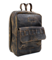 A brown vintage-style, vegetable-tanned leather backpack named "Kamet" by Bed Stu with a front pocket and double top handles is photographed against a white background.