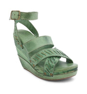 A women's green Bed Stu wedge sandal with straps and buckles.