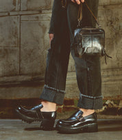 A woman wearing Kavi black jeans and Bed Stu leather loafers.