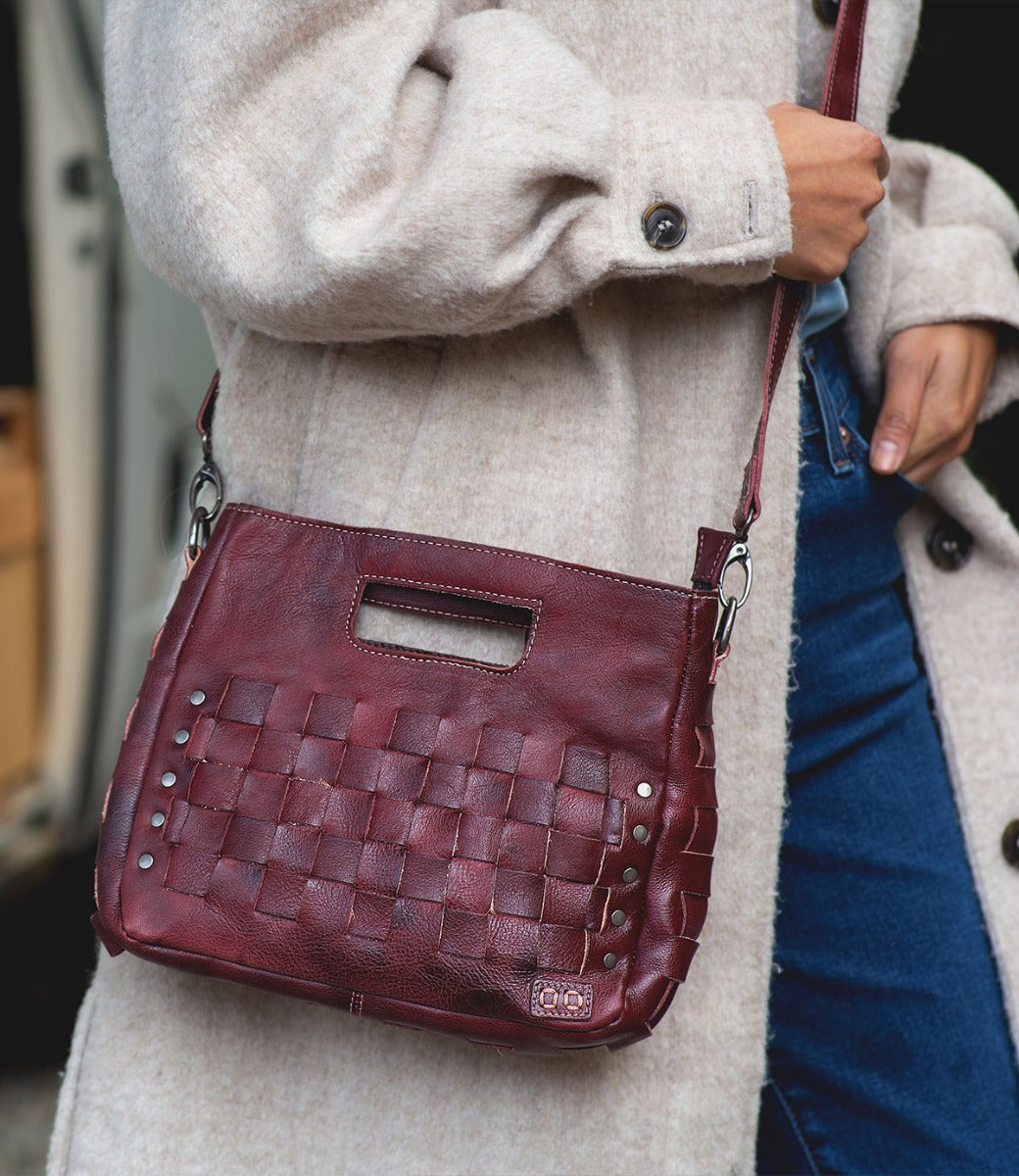 A woman is holding a Keiki handbag by Bed Stu.