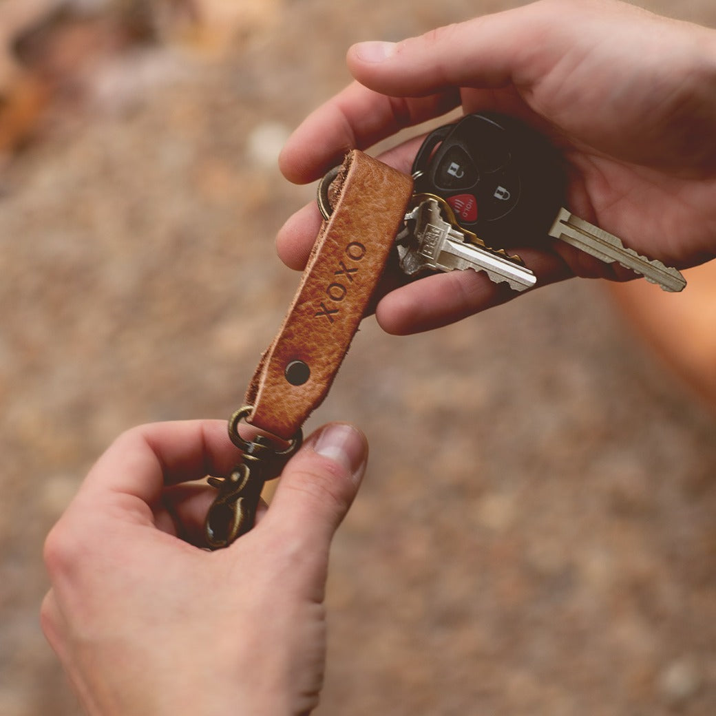 A person holding a Bed Stu Keygrab keychain and keys.