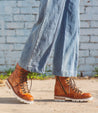 A woman wearing Khya boots by Bed Stu, made of pure leather with brown laces.